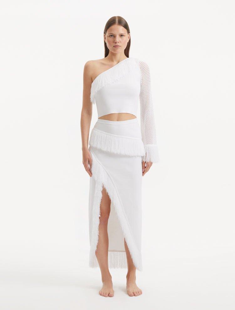 "Model showcasing the Monroe White Top and Alani Skirt from the front, highlighting the one-shoulder design and the textured mesh knit. "