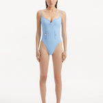 Model showcasing the Muriel Baby Blue Swimsuit with a V-shape detail, highlighting its tranquil hue and elegant design.