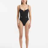 Model showcasing the Muriel Black Swimsuit with a central V-shape detail, highlighting its elegant and fluid design.