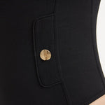 Close-up of the shell-shaped gold button details on the Muriel Black Swimsuit, showcasing its luxurious accents.