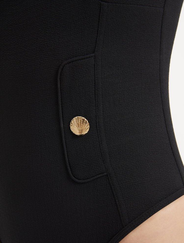 Close-up of the shell-shaped gold button details on the Muriel Black Swimsuit, showcasing its luxurious accents.