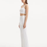 "Model wearing the Murphy White Top from the side, highlighting the scoop neckline and elasticated band. "