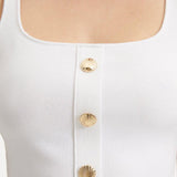 "Close-up view of the Murphy White Top, highlighting the intricate hand-knitted texture and shell-shaped gold buttons. "