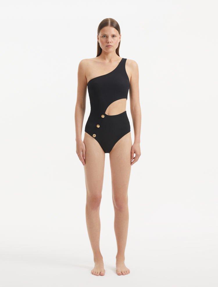 Model wearing the Narella Black Swimsuit, showcasing the elegant one-shoulder design and cutout detail.