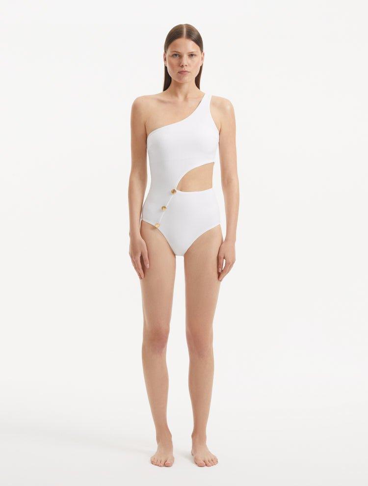 Model showcasing the Narella White Swimsuit, highlighting the elegant one-shoulder design and cutout detail.