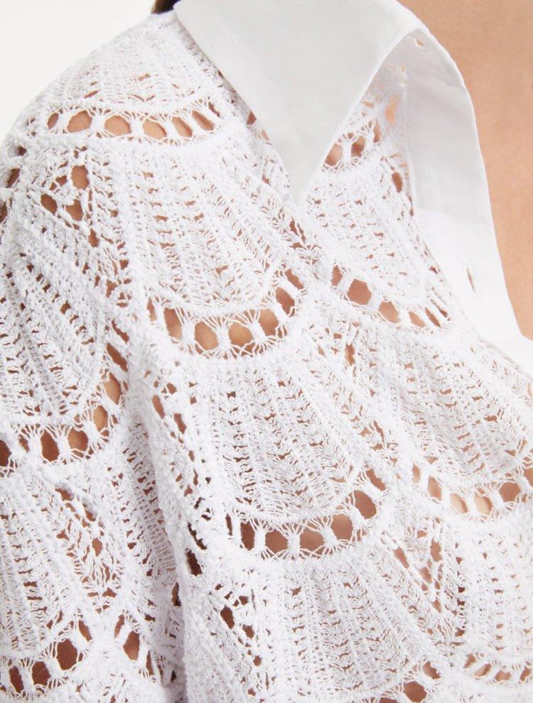 "Close-up of the Nayeli White Dress’s broderie anglaise fabric, displaying the intricate eyelet patterns and delicate lace-like texture."