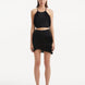"Model showcasing the Nebula Black Top and Arlo Skirt from the front, highlighting the delicate knitting patterns, vibrant black color, and distinctive tie-neck detail. "