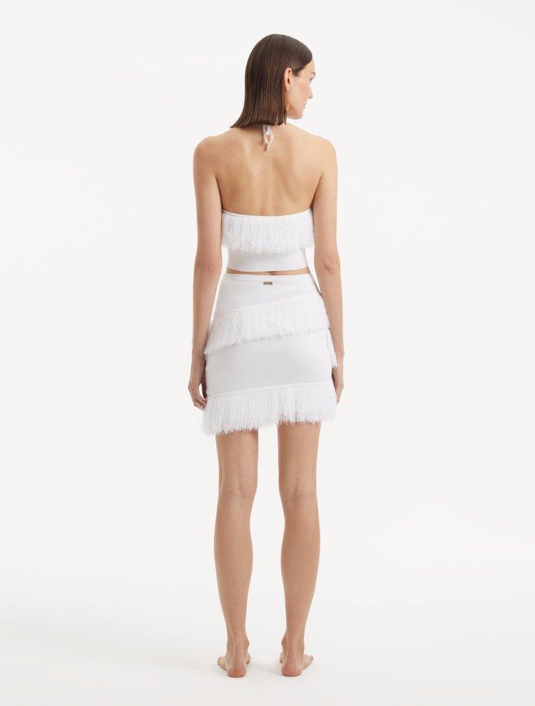 "Model displaying the Nebula White Knit Top from the back, focusing on the clean lines and tie-neck detail. "