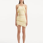 "Model wearing the Nebula Yellow Top and Arlo Yellow Skirt from the front, showcasing the vibrant yellow color, delicate knitting patterns, and distinctive tie-neck detail. "