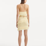 "Model displaying the Nebula Yellow Top and Arlo Yellow Skirt from the back, emphasizing the smooth, clean lines and tie-neck detail. "