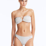 Front View: Model Wearing Nixie Silver Bikini Top - Bandeau Style, Chic and Accessorized, Metallic Fabric, Clear Glass Drop Shaped Accessory, MOEVA Luxury Swimwear