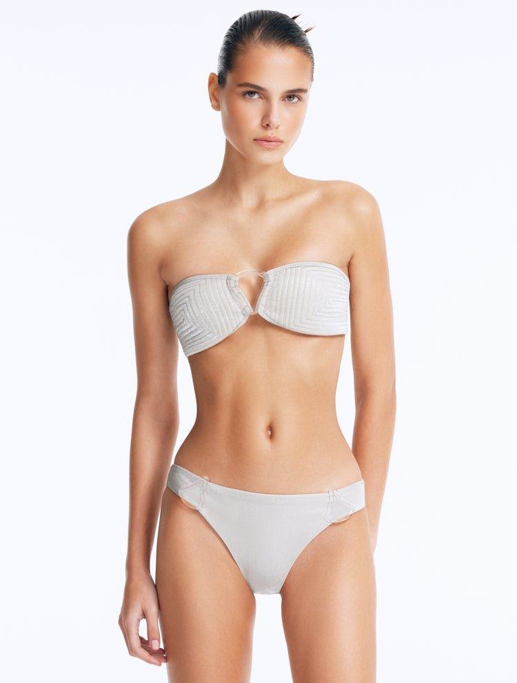 Front View: Model Wearing Nixie Silver Bikini Top - Bandeau Style, Chic and Accessorized, Metallic Fabric, Clear Glass Drop Shaped Accessory, MOEVA Luxury Swimwear