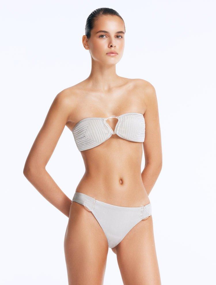 Model wearing the Nixie Silver Bikini Set, showcasing the bandeau top with clear glass drop accents.
