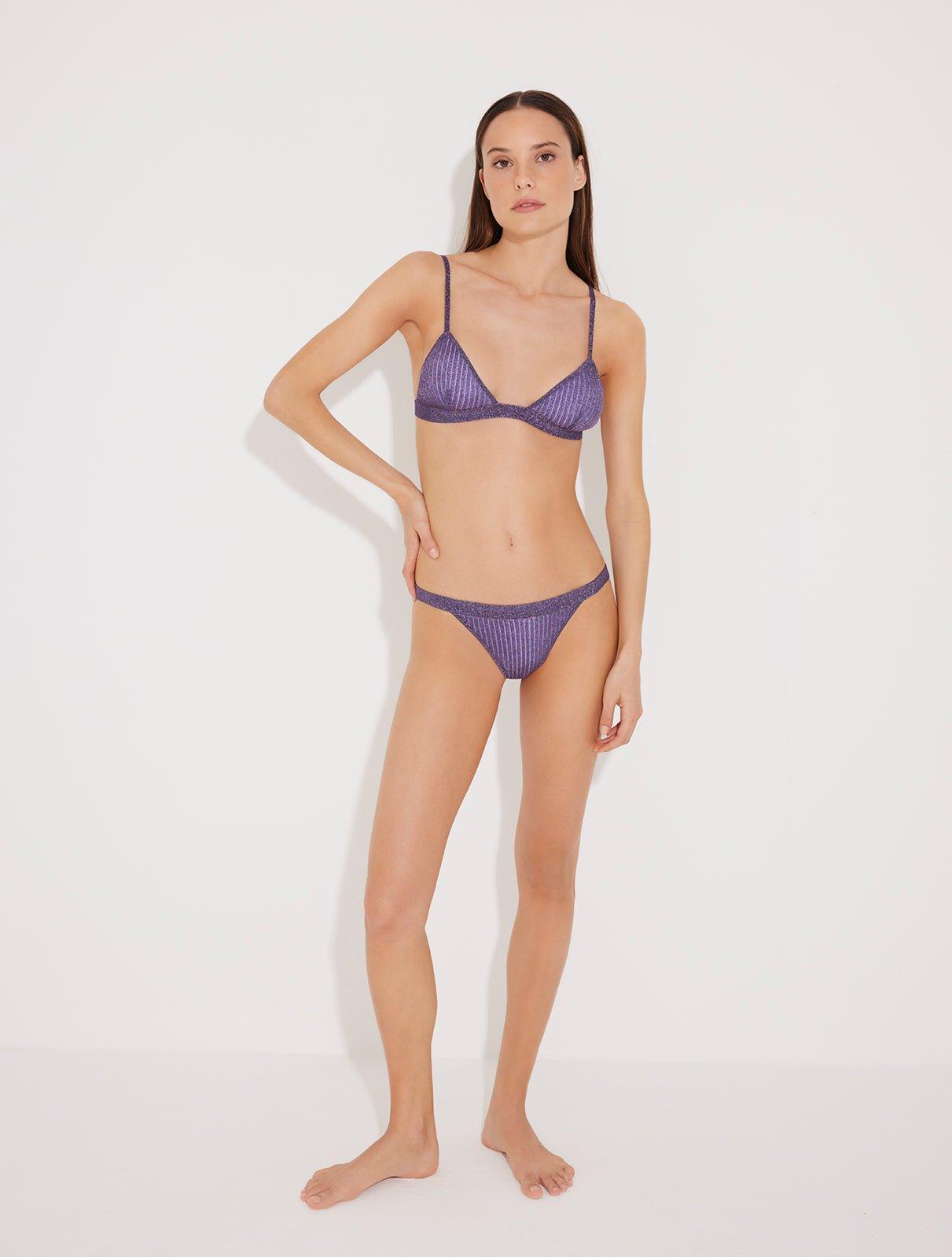  "Model wearing the North lilac metallic bikini set, front view showing the ribbed knit triangle top with adjustable straps and metallic sheen."