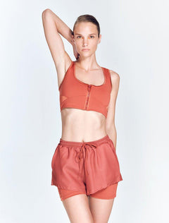 "Front view of Ondine Red Ochre Shorts showing double-layered design, stretchable fabric, and adjustable waistband. The thigh-length shorts are fitted and stylish, ideal for various activities."