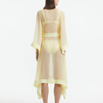 "Back view of the Opal Yellow Kaftan, featuring the shell-shaped gold button details and the sheer fabric."