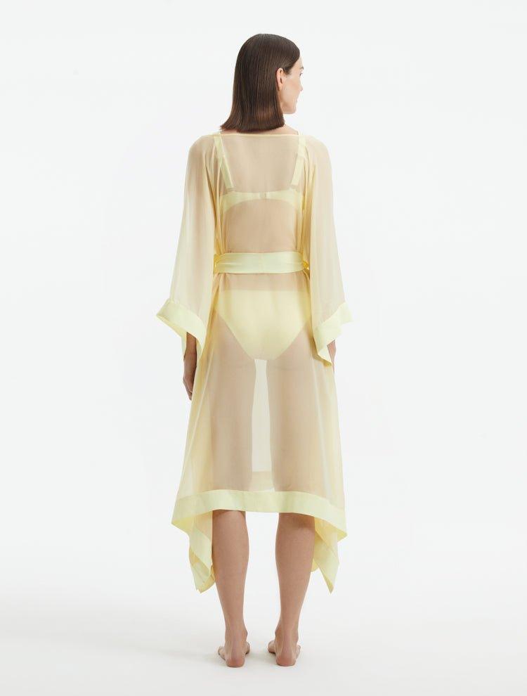 "Back view of the Opal Yellow Kaftan, featuring the shell-shaped gold button details and the sheer fabric."