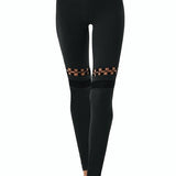  "Orla Black Leggings back view, displaying the mesh and cut-out panel design. The leggings offer a stylish and functional look with a stretchable fit."