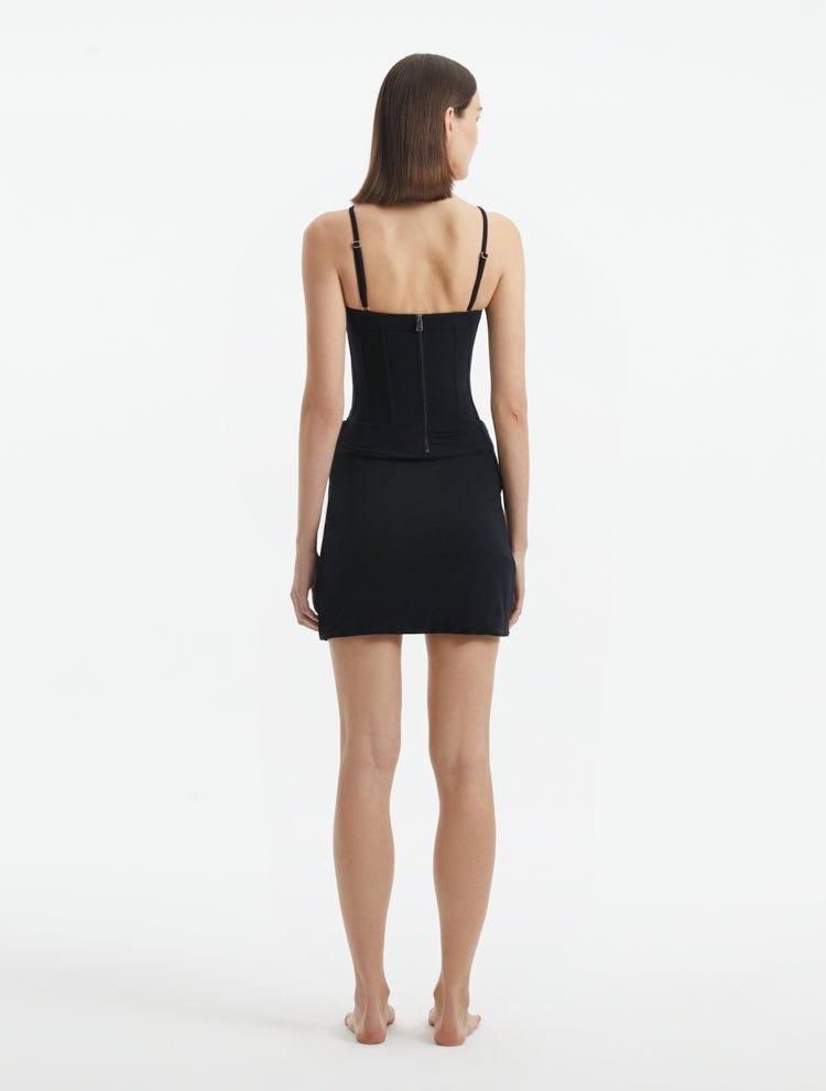 Back View: Model in Osaka Black Dress - MOEVA Luxury Swimwear, Zip Through Back Fastening, Wrap Style Skirt, Mid-Thigh Length, Made of Swimwear Fabric, Special Lycra Xtralife Certificate, MOEVA Luxury Swimwear