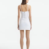 Back View: Model in Osaka White Dress - MOEVA Luxury Swimwear, Zip Through Back Fastening, Wrap Style Skirt, Mid-Thigh Length, Made of Swimwear Fabric, Special Lycra Xtralife Certificate, MOEVA Luxury Swimwear