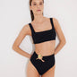 Front View: Model in Patrizia Black Bikini Bottom - MOEVA Luxury Swimwear, High-Waist, Cut-out Detail, Gold Sculpted Hoop Accessory, Moderate Bottom Coverage, MOEVA Luxury Swimwear  