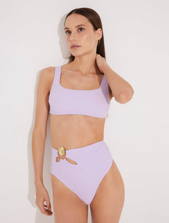 Front View: Model in Patrizia Lilac Bikini Bottom - MOEVA Luxury Swimwear, High-Waist, Cut-out Detail, Gold Sculpted Hoop Accessory, Moderate Bottom Coverage, MOEVA Luxury Swimwear  