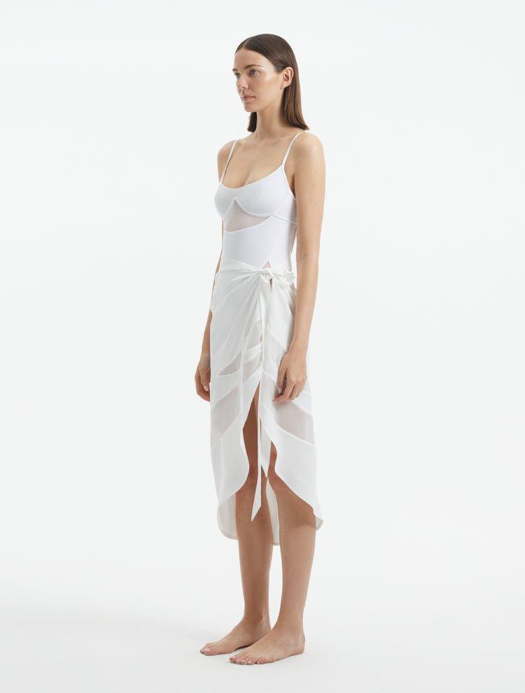 "Side view of the Pelagia White Pareo, showcasing its loose fit and the fluid, translucent fabric."