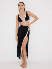 "Model wearing Pina Black/White Skirt from the front, highlighting its chic asymmetrical design and side slit."