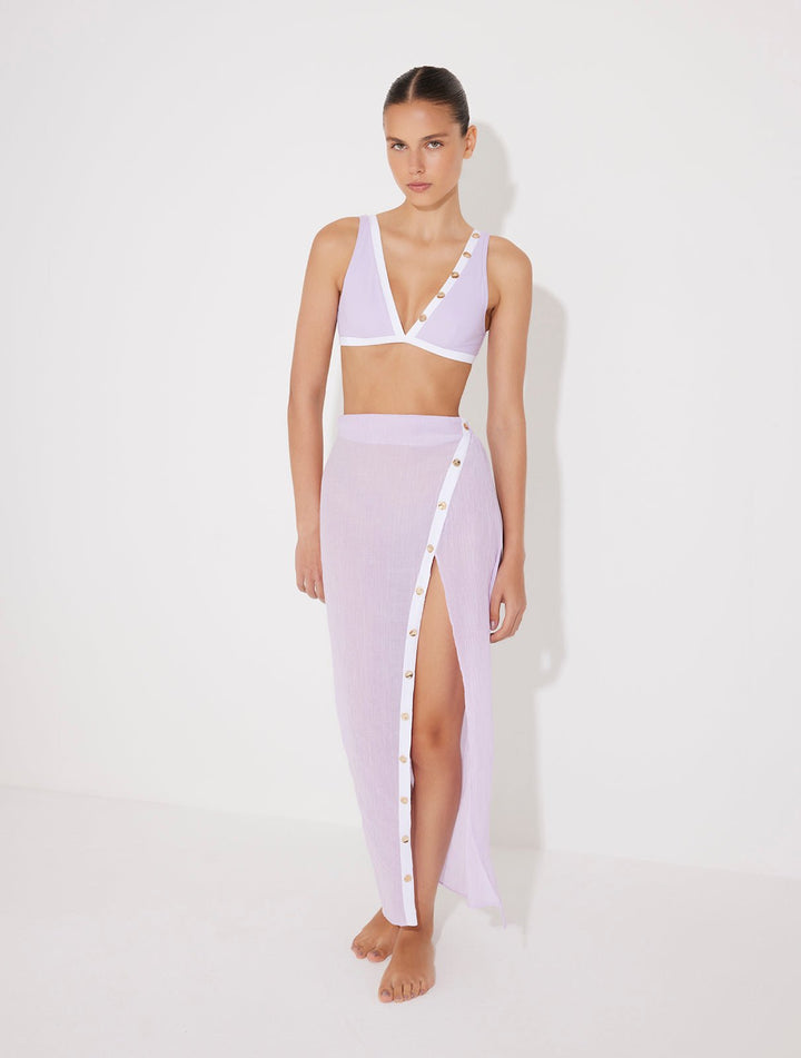 Front View: Model in Pina Lilac/White Skirt - MOEVA Luxury Swimwear, Gold Button Detail Throughout, Side Asymmetrical Skirt, Elasticated Waistband, Maxi Skirt, Front Slit, MOEVA Luxury Swimwear