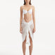 "Model wearing the Raiden White Pareo from the front, highlighting the playful wavy detail and adjustable front tie."
