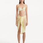 "Model wearing the Raiden Yellow Pareo from the front, featuring the playful wavy detailing and adjustable front tie."