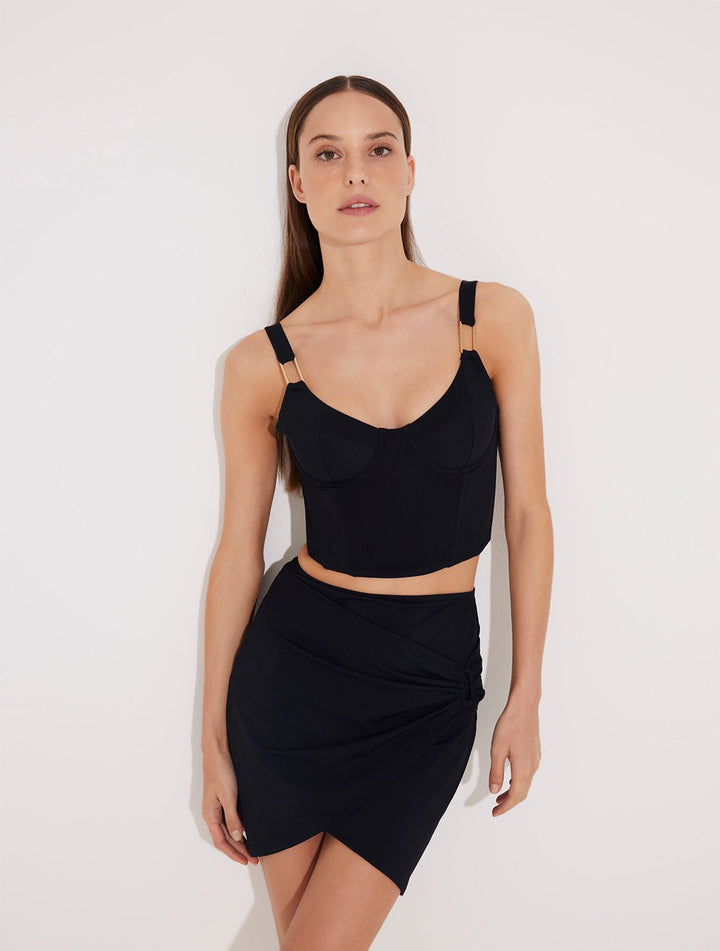 Front View: Model in Ramona Black Skirt - MOEVA Luxury Swimwear, Wrap Style, Slim Fit, High Rise, Thigh Length Skirt,  MOEVA Luxury Swimwear