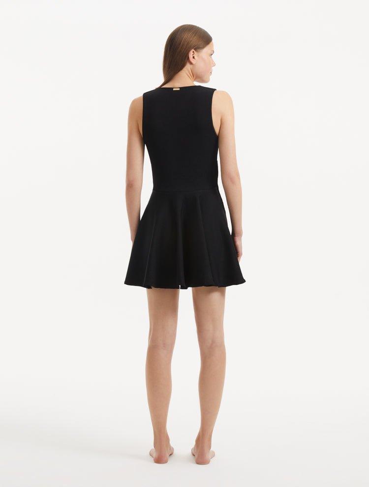 "Model displaying the Rayan Black Dress from the back, focusing on the smooth knit texture and the thigh-length cut."
