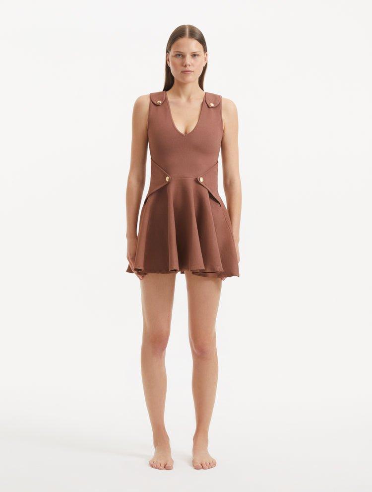 "Model wearing the Rayan Brown Dress from the front, showcasing the premium knitted fabric, the rich brown hue, and the shell-shaped gold buttons."