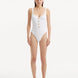 Model showcasing the Reva White Swimsuit, highlighting the scoop neckline and shell-shaped gold buttons.