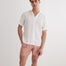 Front View: Model in Romeo White Shirt - MOEVA Luxury Swimwear, Spread Collar, Buttoned Cuffs, Button Fastening, Tailored Italian Linen, Short-Sleeved, MOEVA Luxury Swimwear