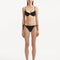 Model wearing the Salila Black Bikini Set, showcasing the textured top and silver clasp details.
