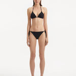 Model wearing the Sarita Black Bikini Set, showcasing the triangle-cut top with refined texture and matching bottoms.