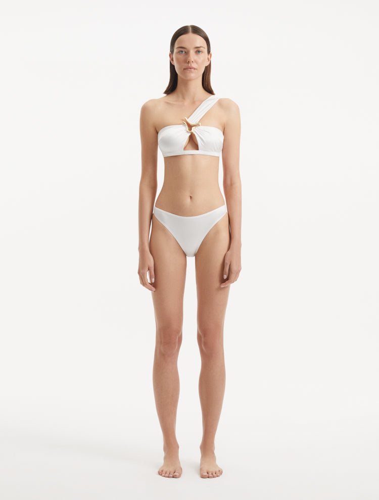 Sereia White Bikini Top front view highlighting its fashionable one-shoulder design and pristine white fabric.