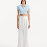 "Model showcasing theShandy Baby Blue Top and Manami White Pants from the front, highlighting the cropped silhouette, elegant V-neckline, and short sleeves. "