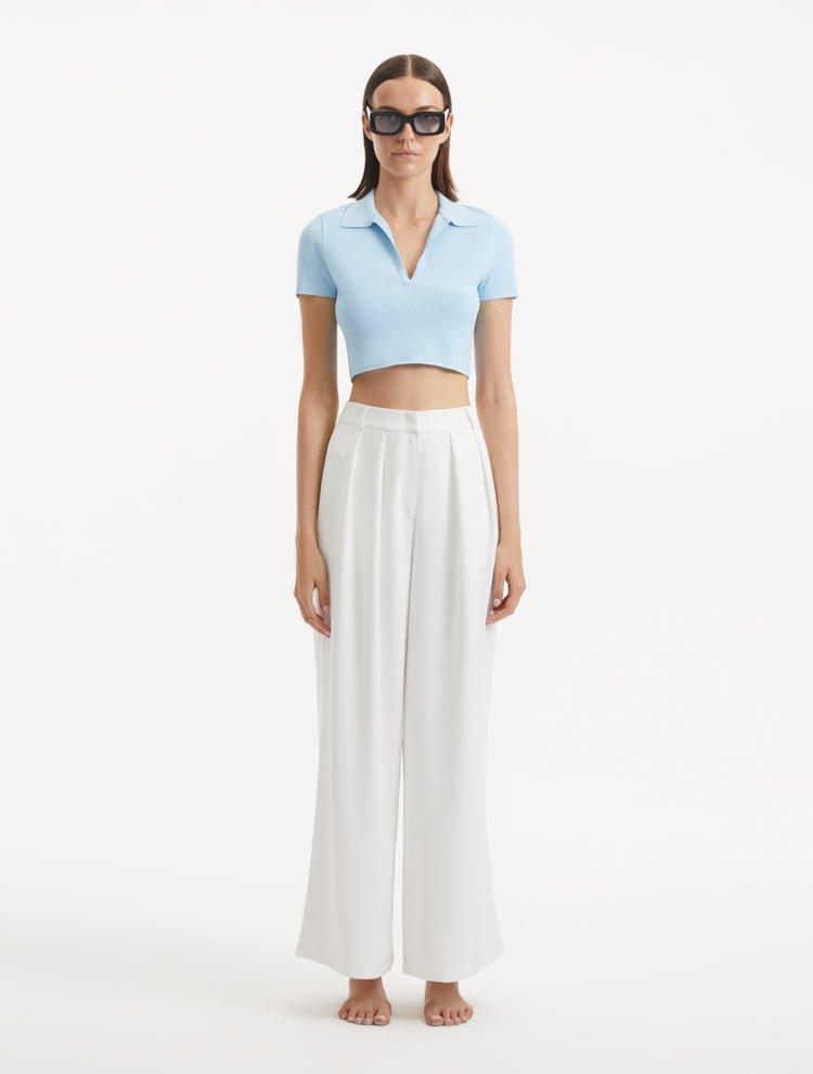 "Model showcasing theShandy Baby Blue Top and Manami White Pants from the front, highlighting the cropped silhouette, elegant V-neckline, and short sleeves. "