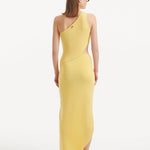 "Model displaying the Shore Yellow Dress from the back, highlighting the asymmetric one-shoulder design and the flowing silhouette that complements the side slit."