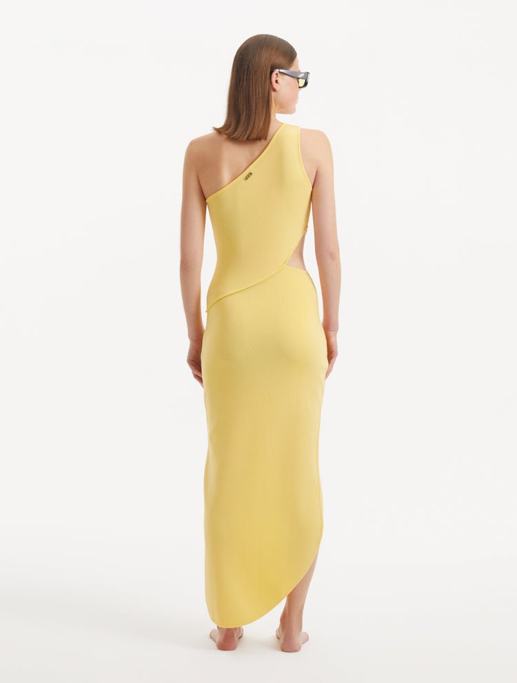 "Model displaying the Shore Yellow Dress from the back, highlighting the asymmetric one-shoulder design and the flowing silhouette that complements the side slit."