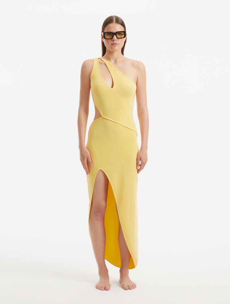 "Model wearing the Shore Yellow Dress from the front, showcasing the vibrant yellow color, one-shoulder design, and the dramatic slash cut-out detail. "