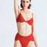 "Model showcasing the Red Skylar Bikini Bottom with high-leg cut and twist detail, viewed from the front."