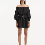 "Model displaying the Sumner Black Dress from the front, emphasizing the ruched neckline, elastic off-the-shoulder design, and long puffed sleeves. "