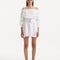"Model showcasing the Sumner White Dress from the front, emphasizing the elastic off-the-shoulder design, ruched neckline, and long puffed sleeves."
