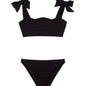 "Front view of the Tia black kids bikini set, highlighting the ruffle details on the bikini top."