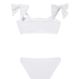 "Back view of the Tia white kids bikini set, focusing on the secure fit of the full-coverage bottoms and adjustable top."