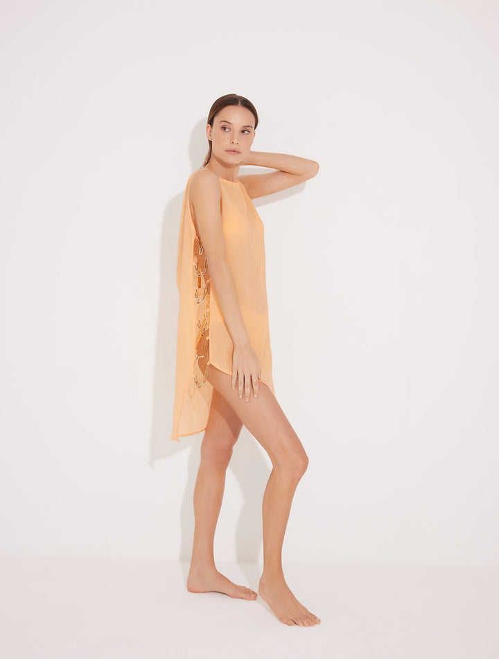 Front View: Model in Veronica Orange Dress - MOEVA Luxury Swimwear, High Neck, Asymmetrical, Open Side, Geometrical Chain Detail At The Side, MOEVA Luxury Swimwear